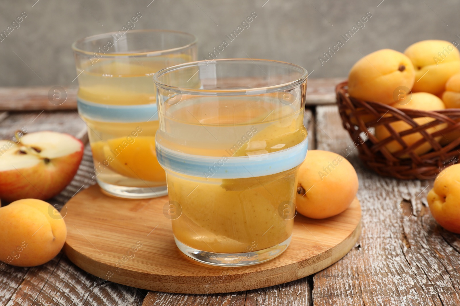 Photo of Tasty compot and fruits on wooden table, closeup