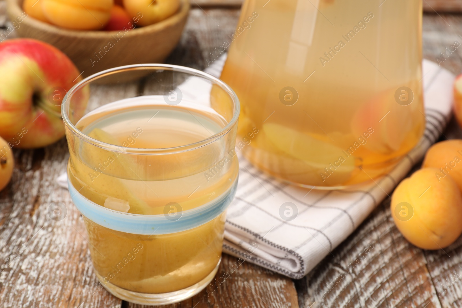Photo of Tasty compot and fruits on wooden table, closeup
