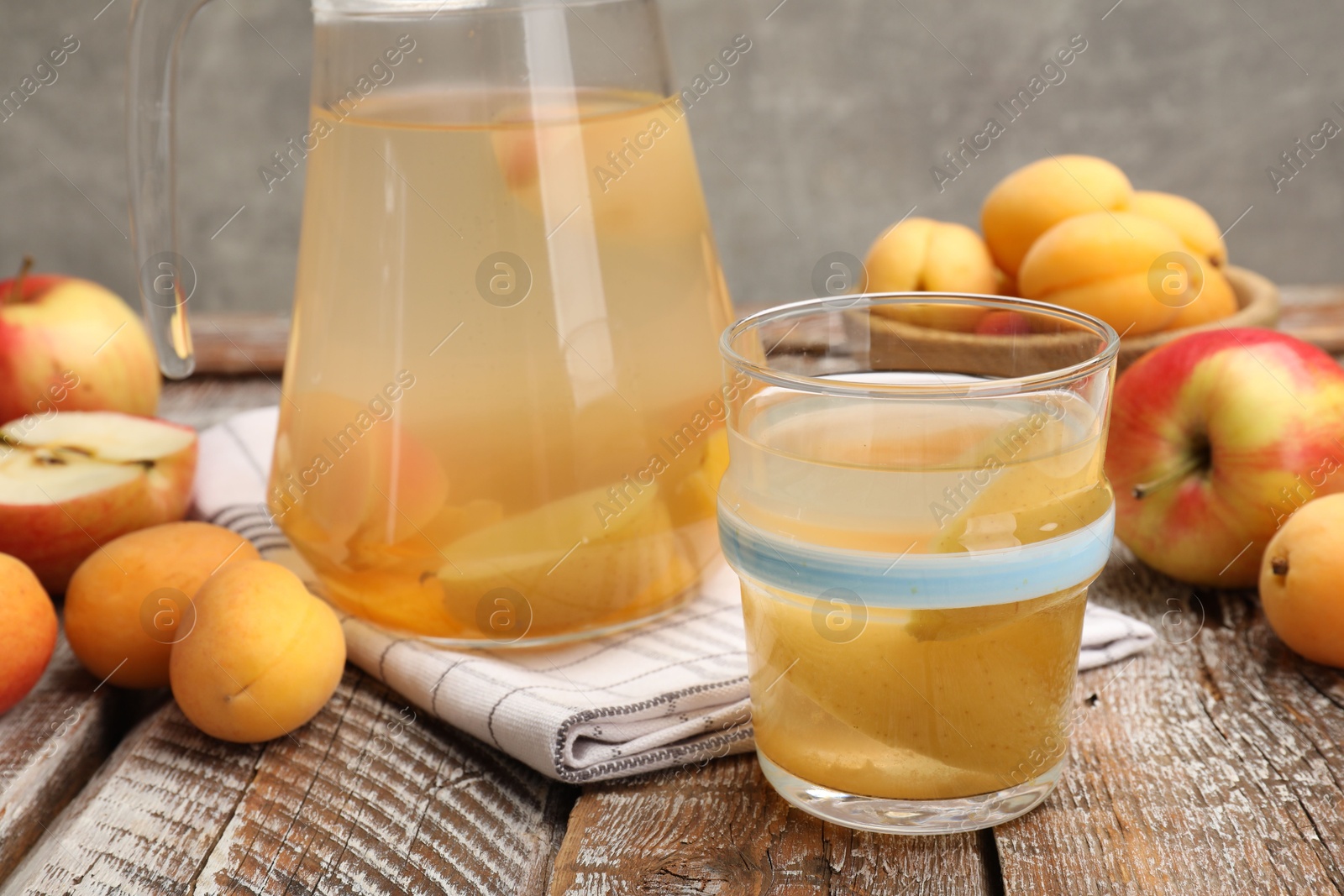 Photo of Tasty compot and fruits on wooden table, closeup