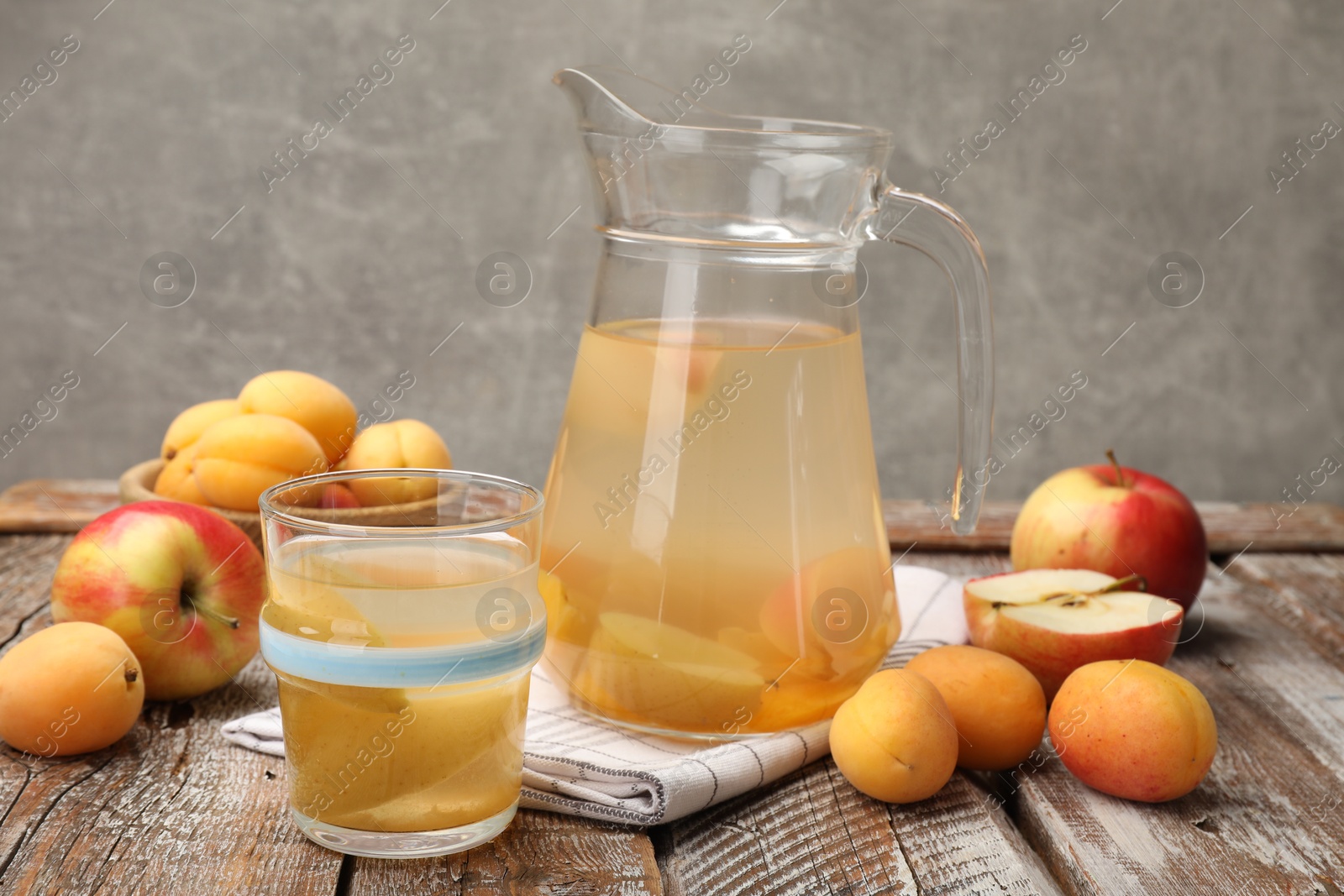 Photo of Tasty compot and fruits on wooden table
