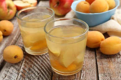 Photo of Tasty compot and fruits on wooden table, closeup