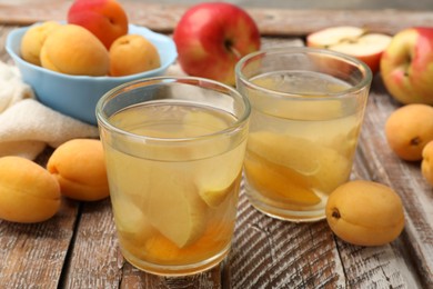 Photo of Tasty compot and fruits on wooden table, closeup