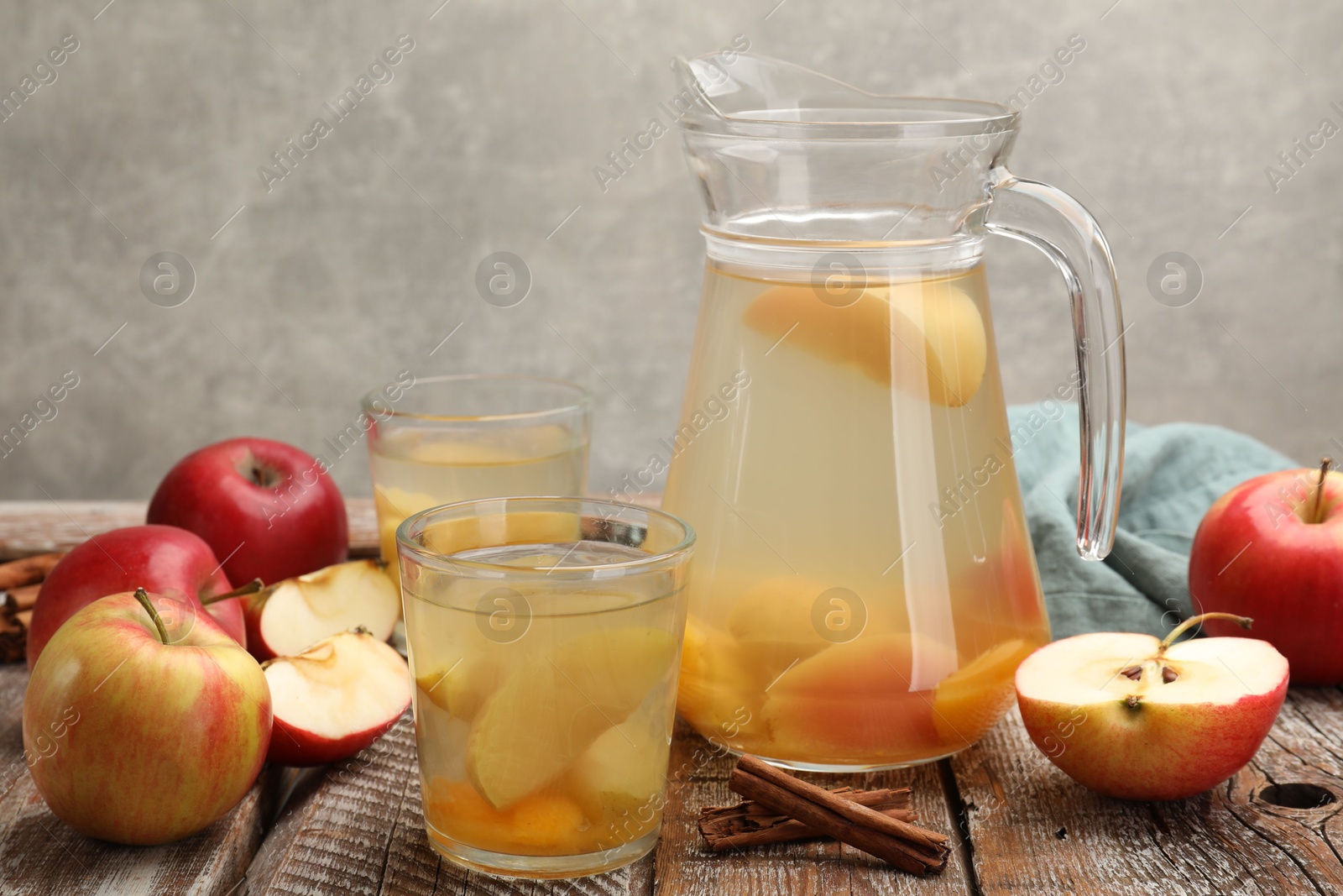 Photo of Tasty compot with apples on wooden table