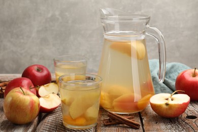 Photo of Tasty compot with apples on wooden table