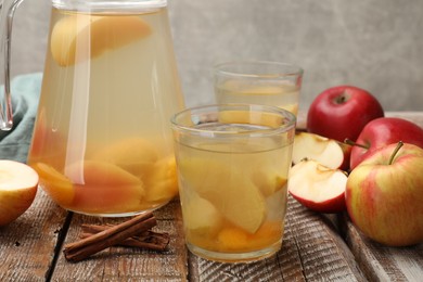 Photo of Tasty compot with apples on wooden table, closeup