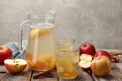 Photo of Tasty compot with apples on wooden table. Space for text