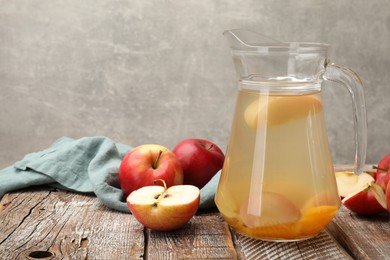 Photo of Tasty compot with apples on wooden table. Space for text