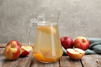 Photo of Tasty compot with apples on wooden table