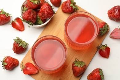 Photo of Tasty compot and strawberries on white table, flat lay