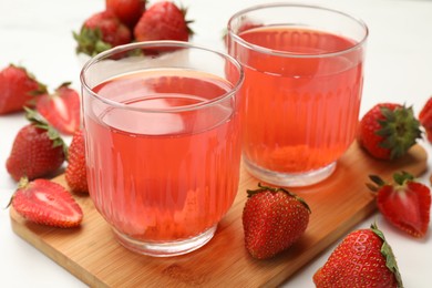 Photo of Tasty compot and strawberries on white table, closeup