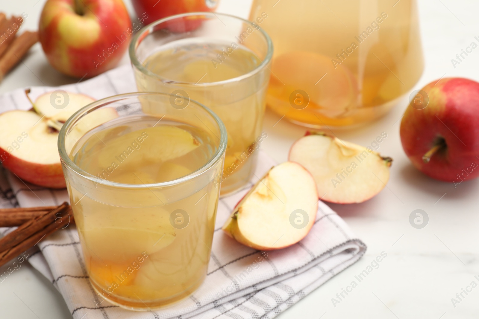 Photo of Tasty compot with apples and cinnamon on white table, closeup