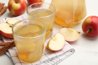 Photo of Tasty compot with apples and cinnamon on white table, closeup