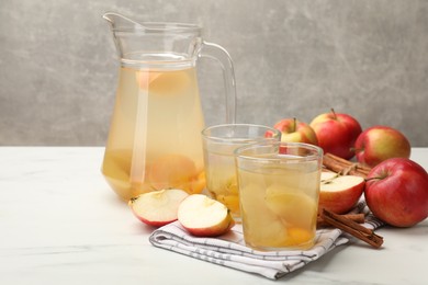 Photo of Tasty compot with apples and cinnamon on white table