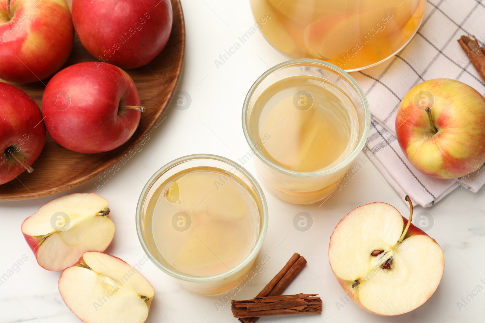Photo of Tasty compot with apples and cinnamon on white table, flat lay