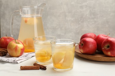 Photo of Tasty compot with apples and cinnamon on white table