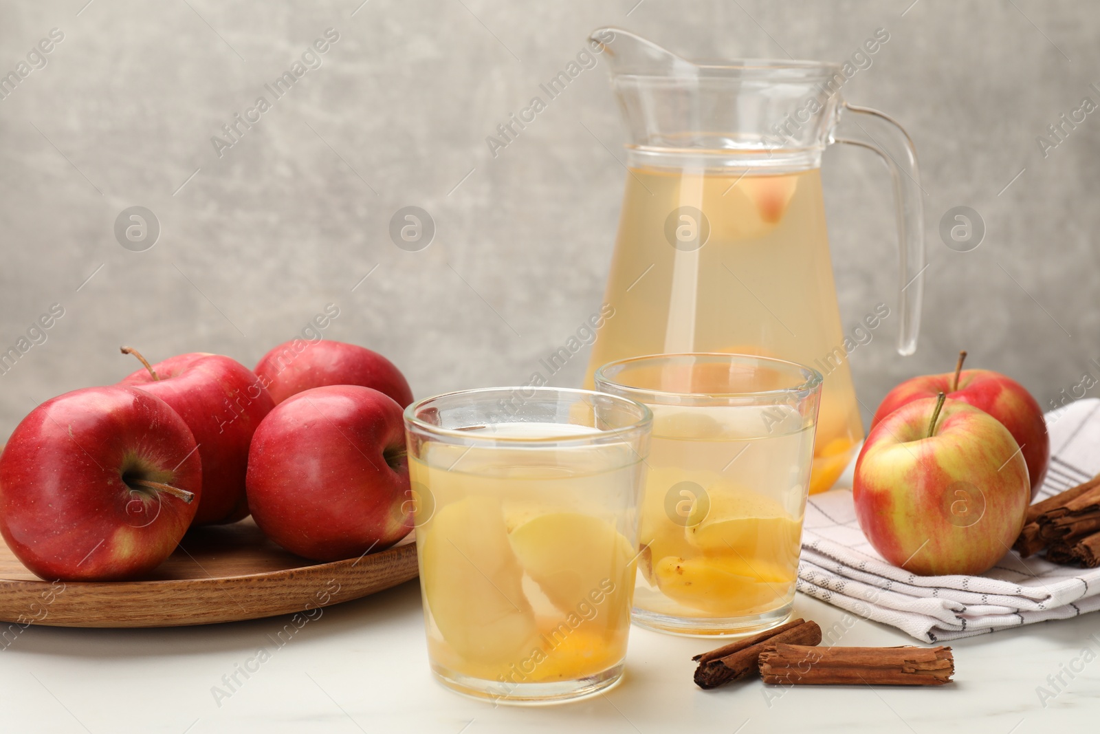 Photo of Tasty compot with apples and cinnamon on white table
