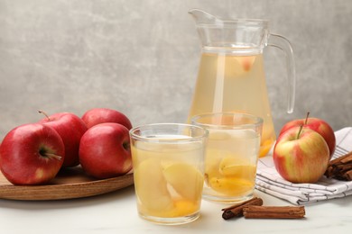 Photo of Tasty compot with apples and cinnamon on white table