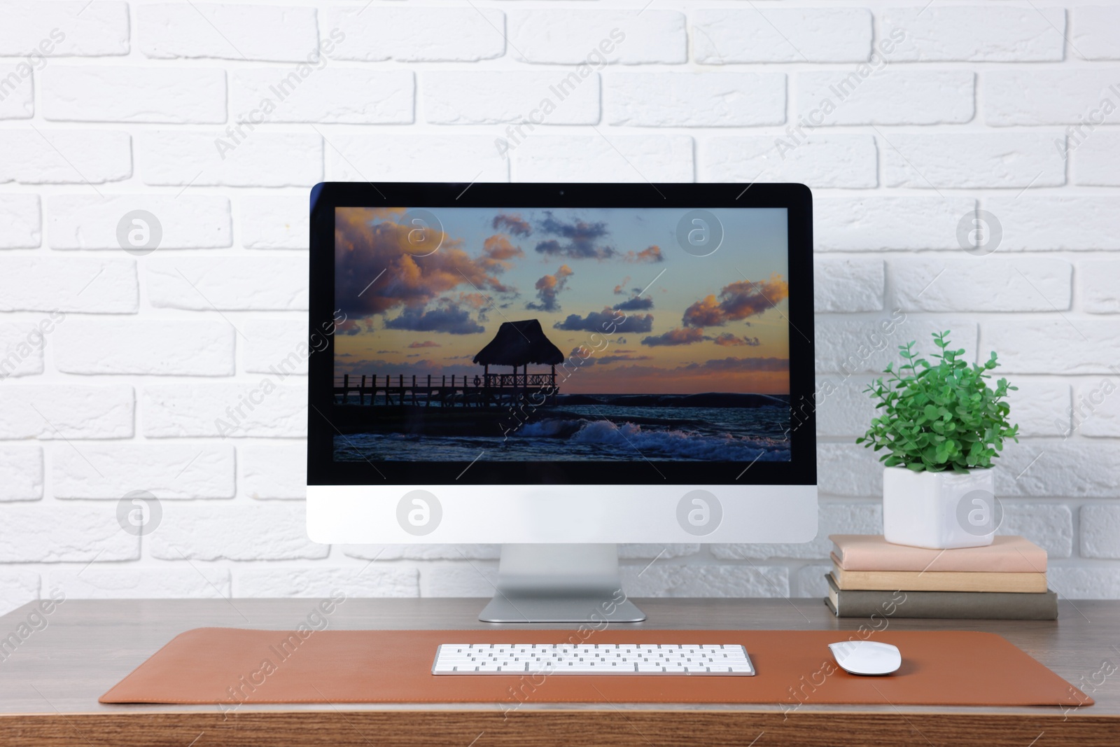 Stylish workplace with computer and orange mousepad on wooden table indoors Photo of Stylish workplace with computer and orange mousepad on wooden table indoors