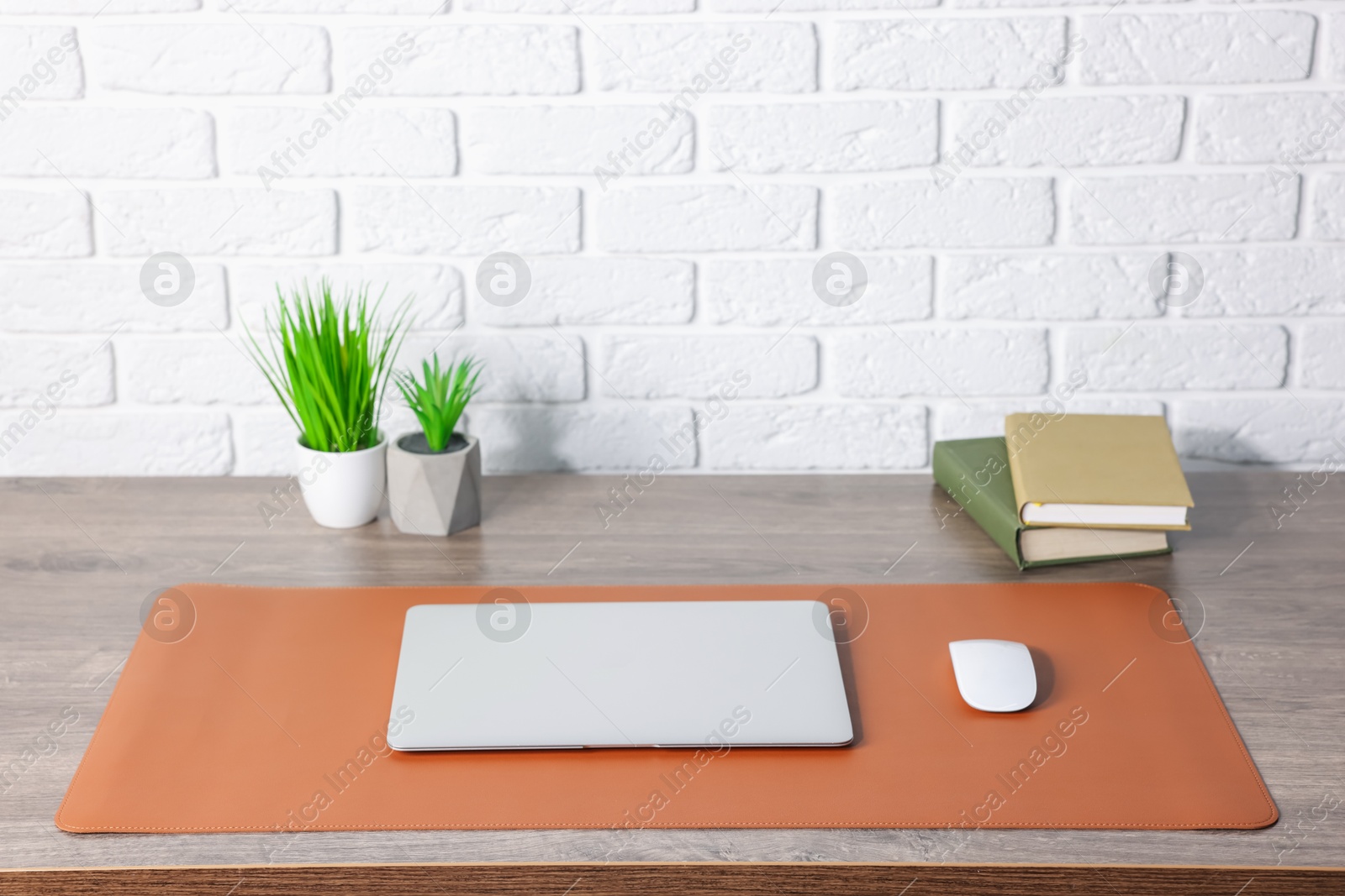 Stylish workplace with laptop and orange mousepad on wooden table indoors. Space for text Photo of Stylish workplace with laptop and orange mousepad on wooden table indoors. Space for text