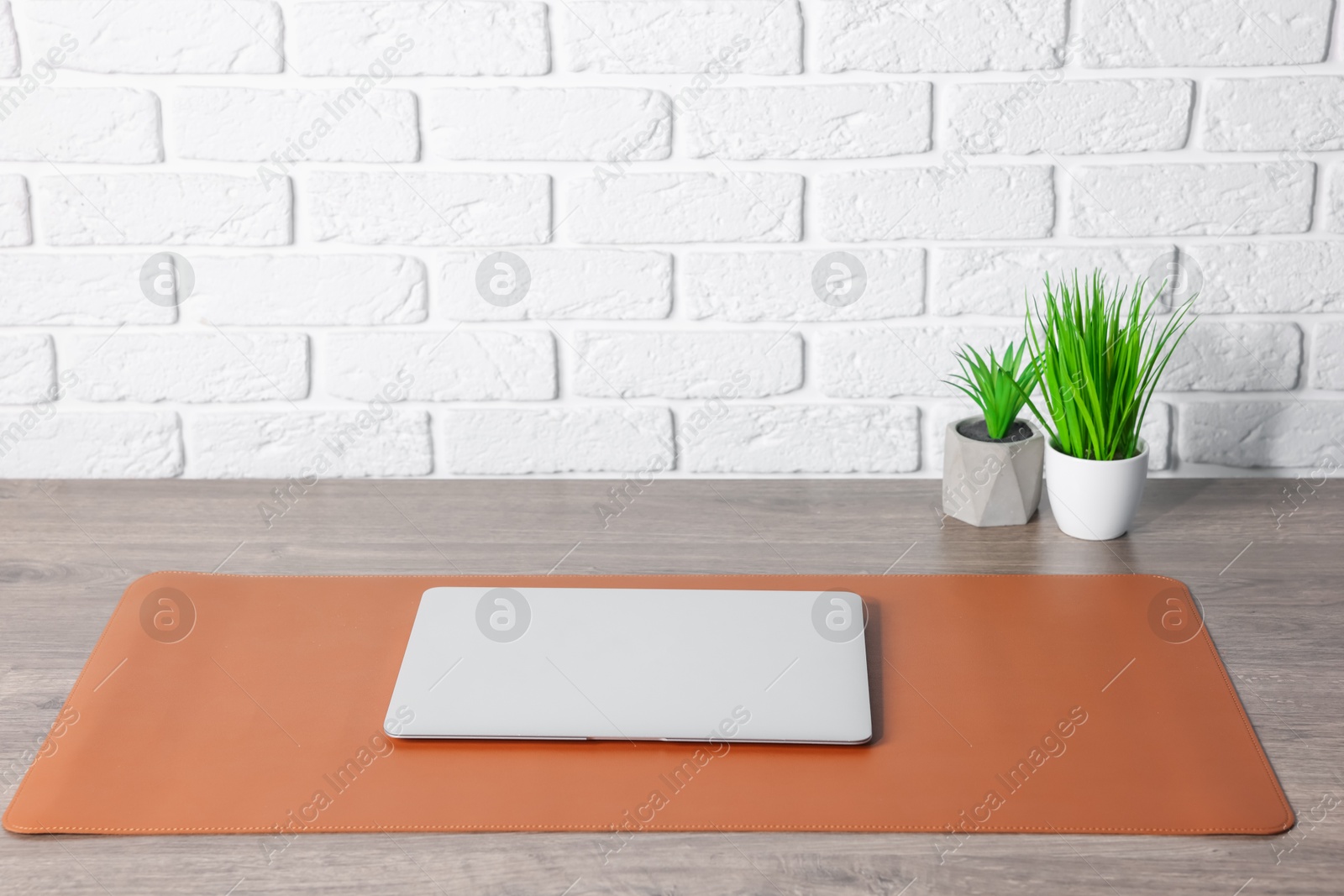 Stylish workplace with laptop and orange mousepad on wooden table indoors. Space for text Photo of Stylish workplace with laptop and orange mousepad on wooden table indoors. Space for text