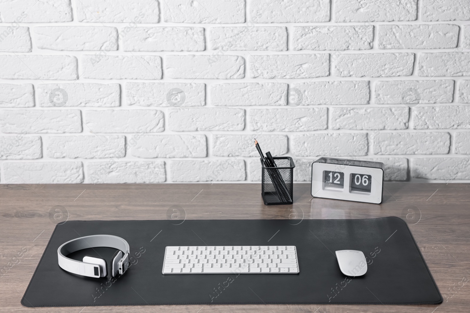 Stylish workplace with computer keyboard and black mousepad on wooden table indoors. Space for text Photo of Stylish workplace with computer keyboard and black mousepad on wooden table indoors. Space for text