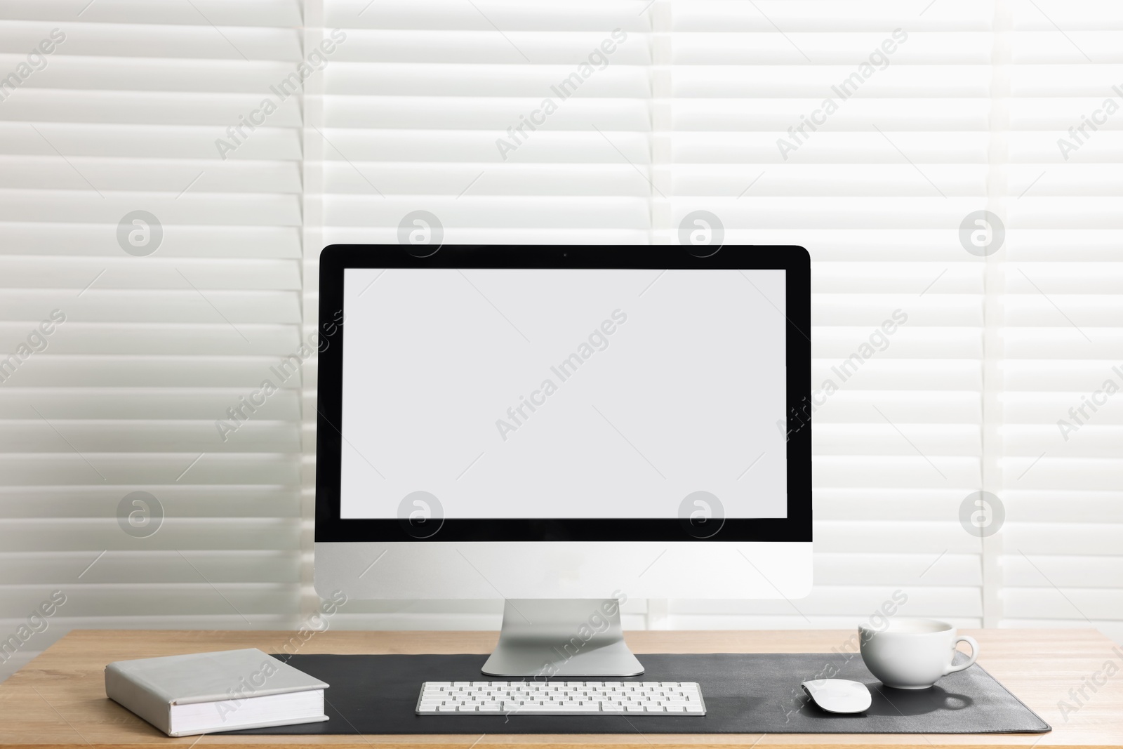 Stylish workplace with computer and black mousepad on wooden table indoors. Space for text Photo of Stylish workplace with computer and black mousepad on wooden table indoors. Space for text