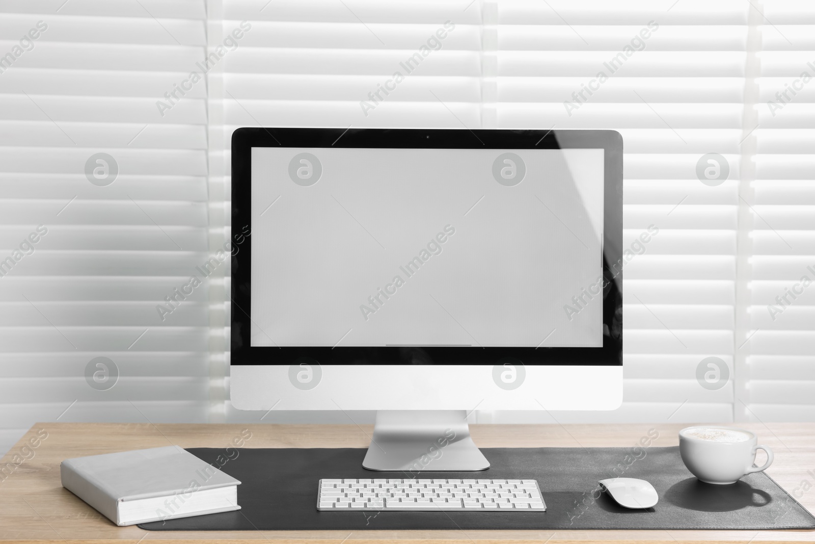 Stylish workplace with computer and black mousepad on wooden table indoors. Space for text Photo of Stylish workplace with computer and black mousepad on wooden table indoors. Space for text