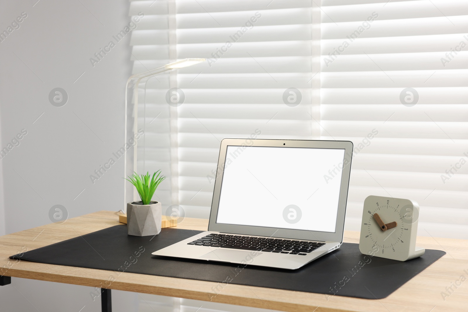 Stylish workplace with laptop and black mousepad on wooden table indoors. Space for text Photo of Stylish workplace with laptop and black mousepad on wooden table indoors. Space for text