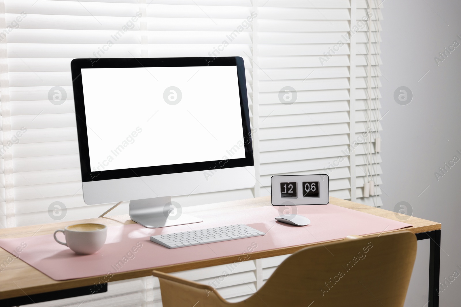 Photo of Stylish workplace with computer and pink mousepad on wooden table indoors. Space for text