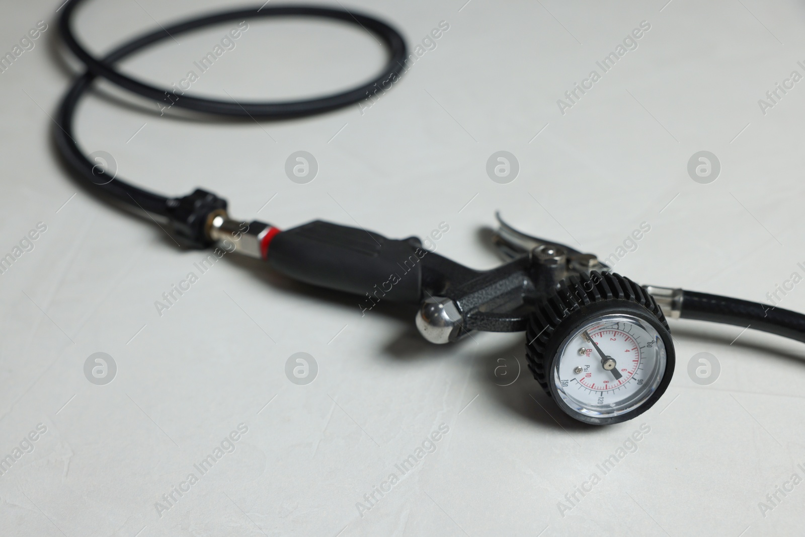 One tire inflation gun with gauge on light background, closeup Photo of One tire inflation gun with gauge on light background, closeup