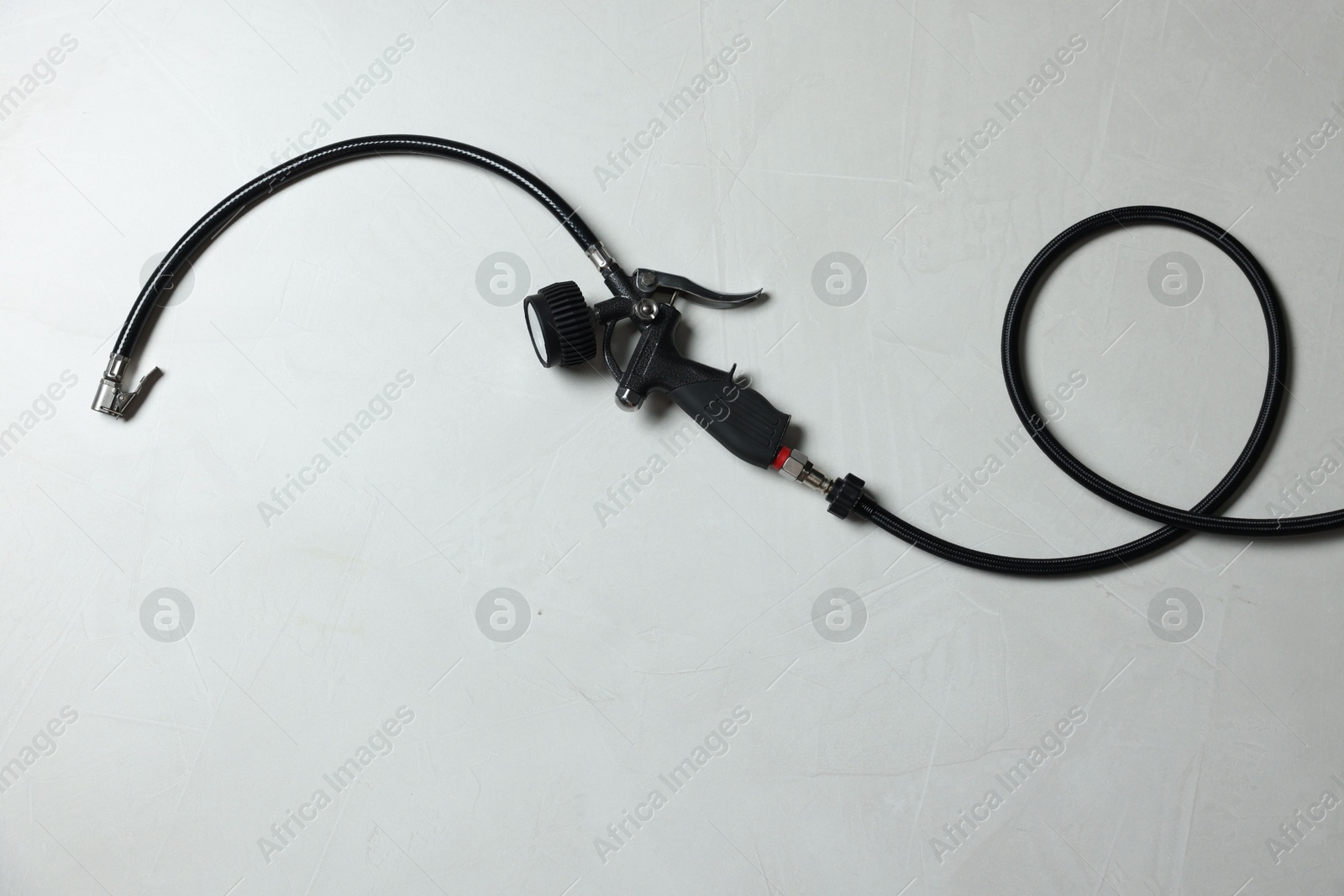 One tire inflation gun with gauge on light background, top view Photo of One tire inflation gun with gauge on light background, top view