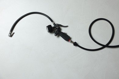 Photo of One tire inflation gun with gauge on light background, top view