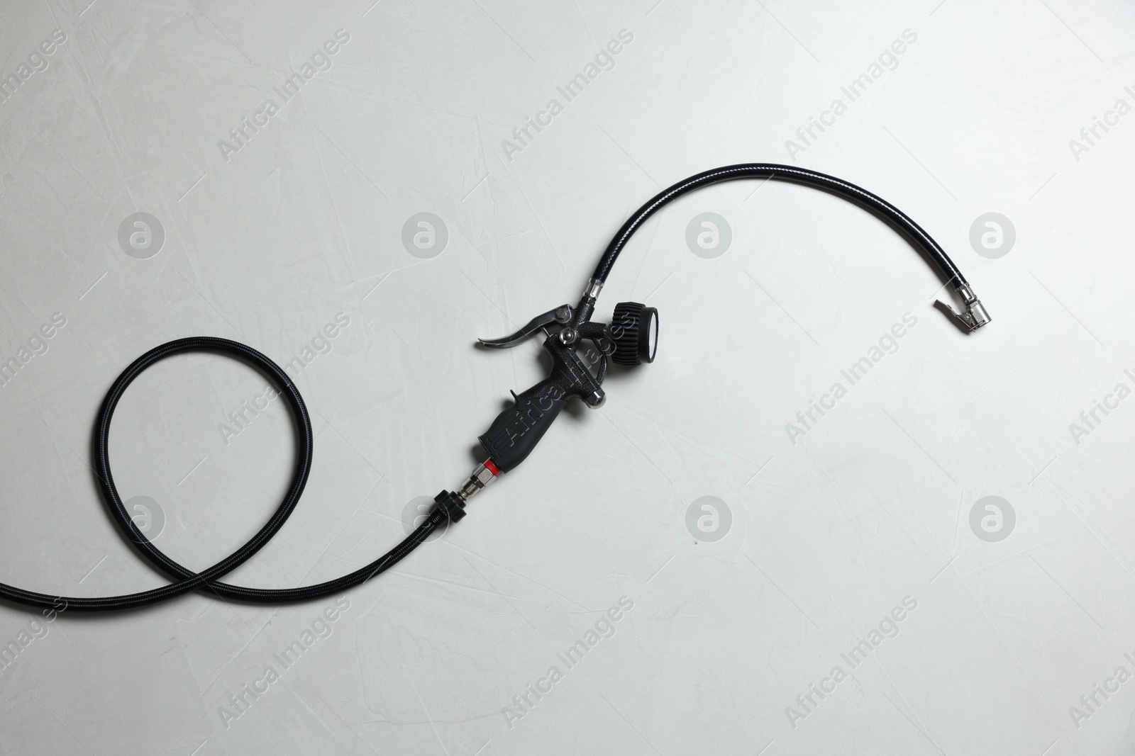 One tire inflation gun with gauge on light background, top view Photo of One tire inflation gun with gauge on light background, top view