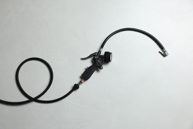 Photo of One tire inflation gun with gauge on light background, top view