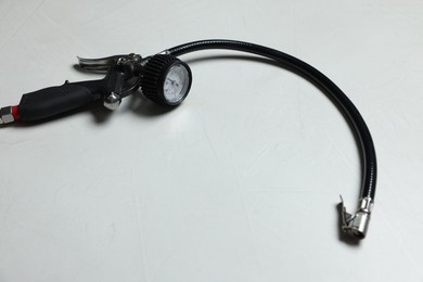 Photo of One tire inflation gun with gauge on light background. Space for text