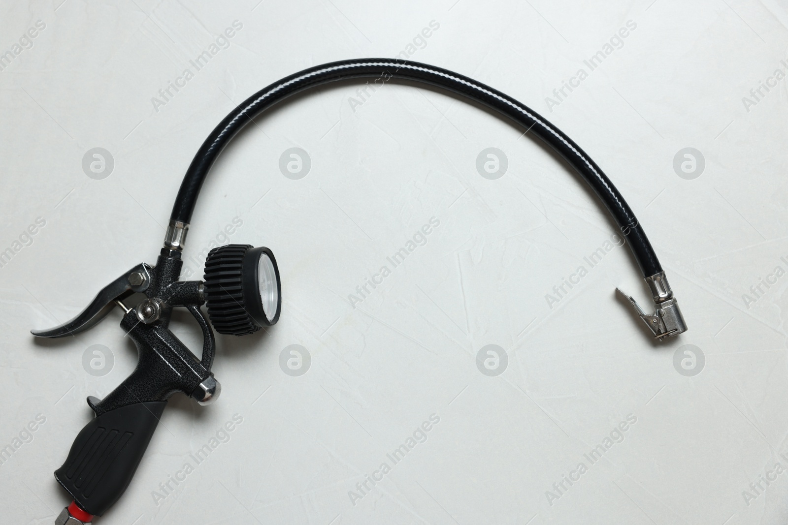One tire inflation gun with gauge on light background, top view Photo of One tire inflation gun with gauge on light background, top view
