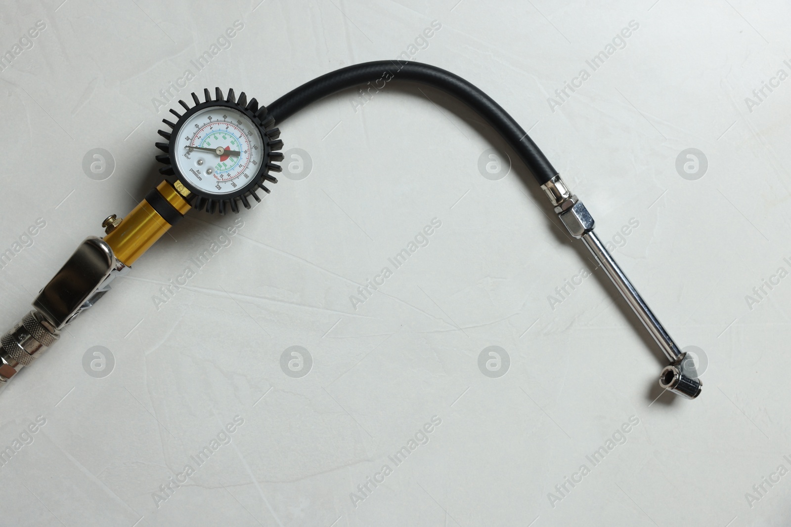 One tire inflation gun with gauge on light background, top view. Space for text Photo of One tire inflation gun with gauge on light background, top view. Space for text