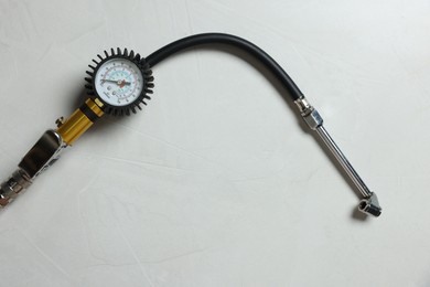 Photo of One tire inflation gun with gauge on light background, top view. Space for text