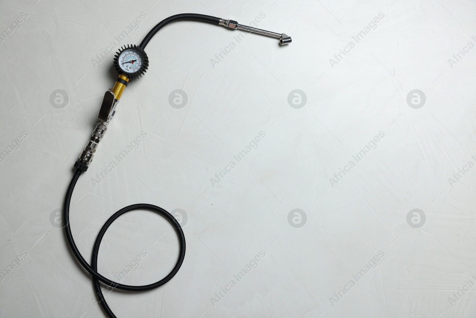 One tire inflation gun with gauge on light background, top view. Space for text Photo of One tire inflation gun with gauge on light background, top view. Space for text