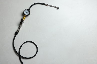 Photo of One tire inflation gun with gauge on light background, top view. Space for text