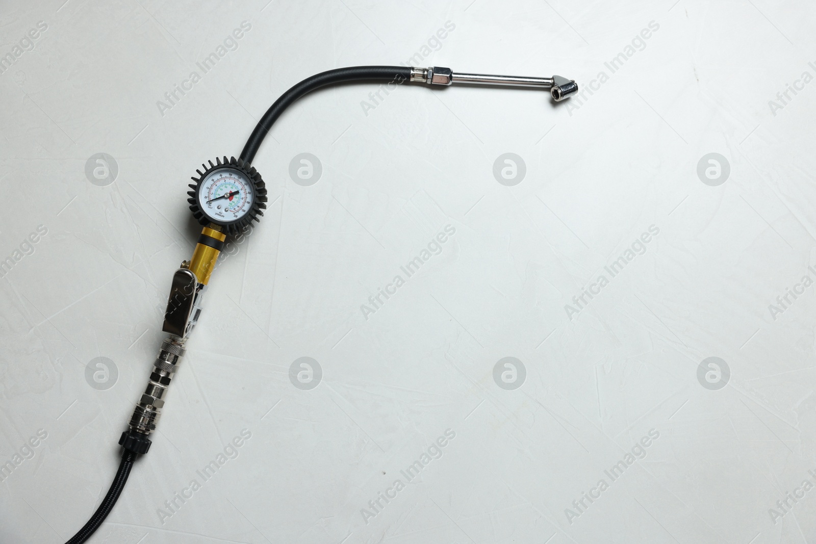 One tire inflation gun with gauge on light background, top view. Space for text Photo of One tire inflation gun with gauge on light background, top view. Space for text