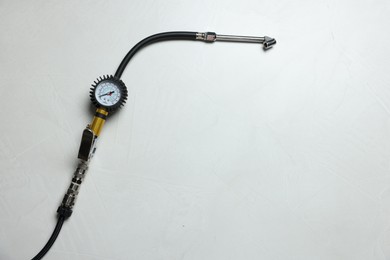Photo of One tire inflation gun with gauge on light background, top view. Space for text