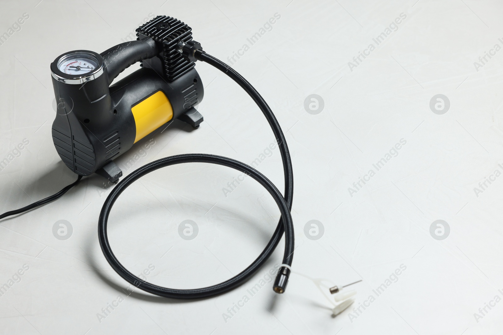 Photo of One modern tire inflator on light background
