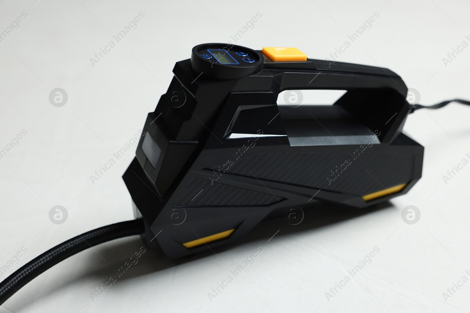 Photo of One modern tire inflator on light background, closeup