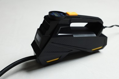 Photo of One modern tire inflator on light background, closeup