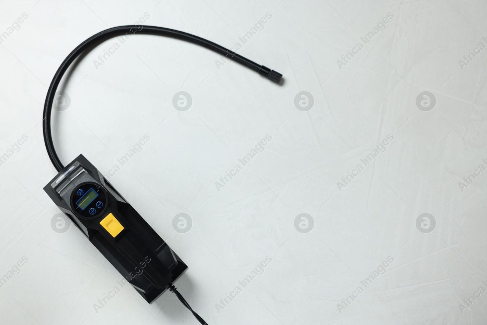 Photo of One tire inflator on light background, top view. Space for text
