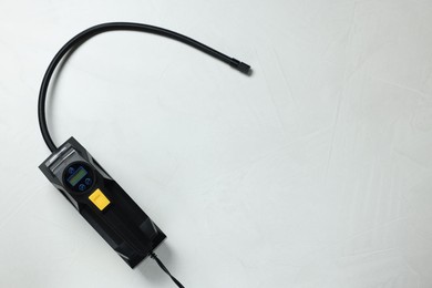 Photo of One tire inflator on light background, top view. Space for text