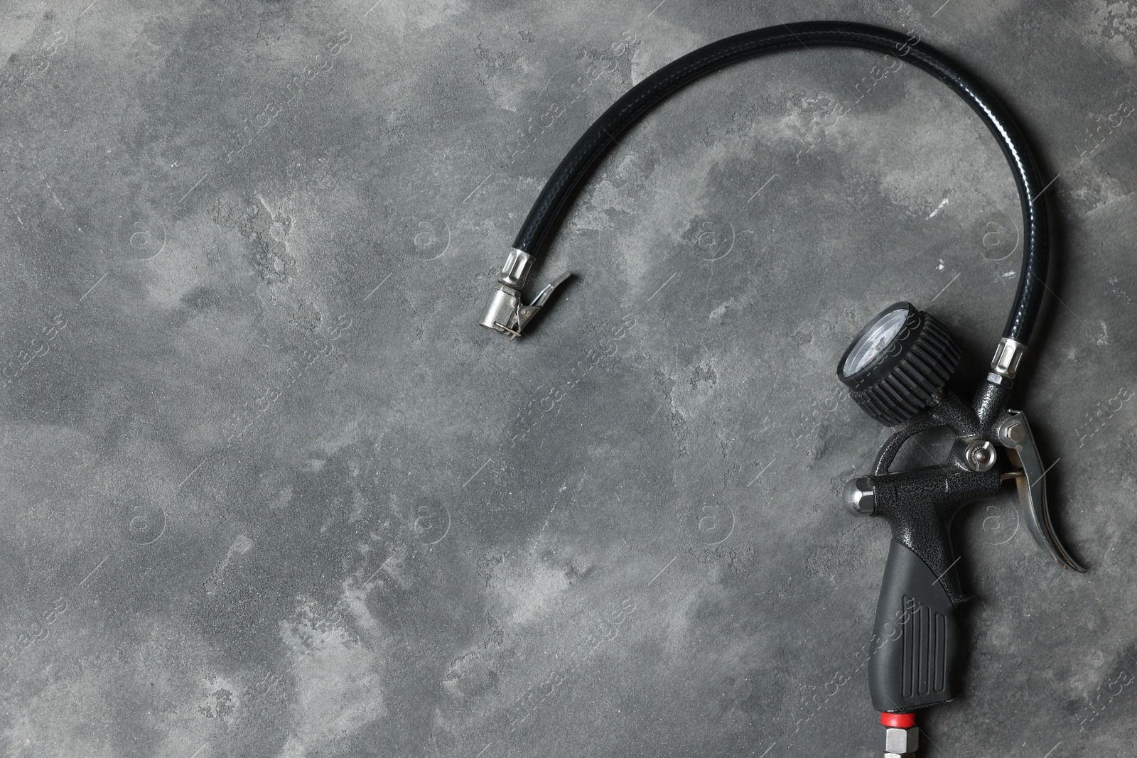 One tire inflation gun with gauge on grey background, top view. Space for text Photo of One tire inflation gun with gauge on grey background, top view. Space for text