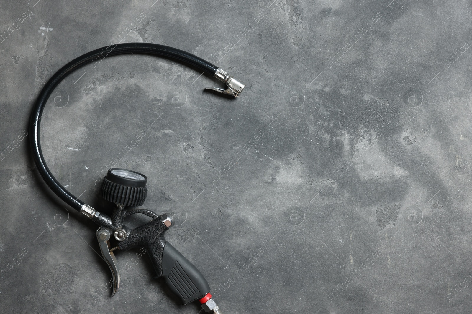 One tire inflation gun with gauge on grey background, top view. Space for text Photo of One tire inflation gun with gauge on grey background, top view. Space for text