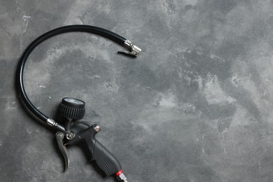 Photo of One tire inflation gun with gauge on grey background, top view. Space for text